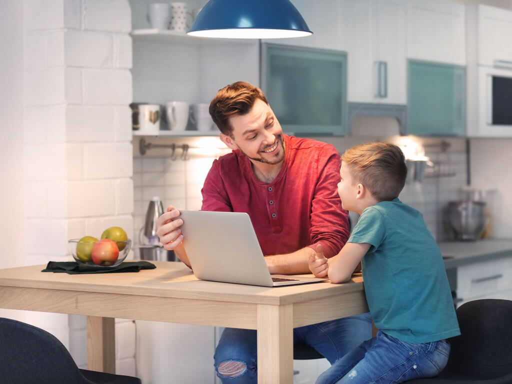 father and son using laptop to discuss kids technology use